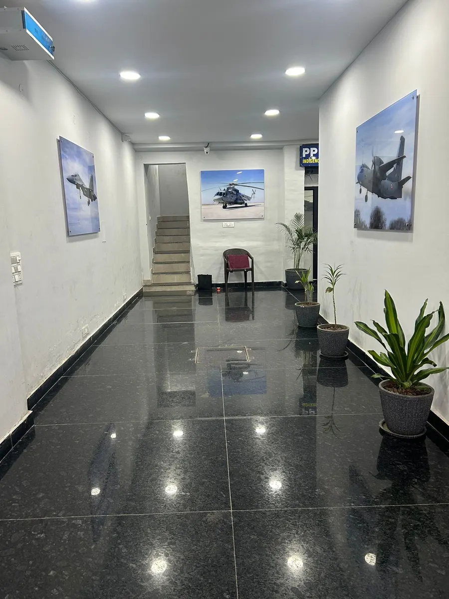 Reception corridor with mounted photographs of military aircraft along both walls.