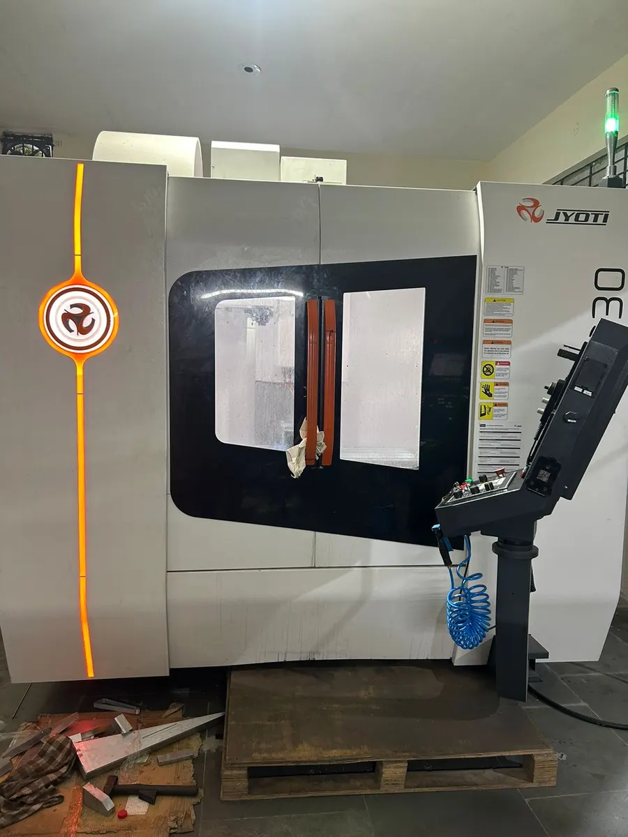 Front of a Jyoti vertical machining centre with its control pendant and illuminated status beacon.